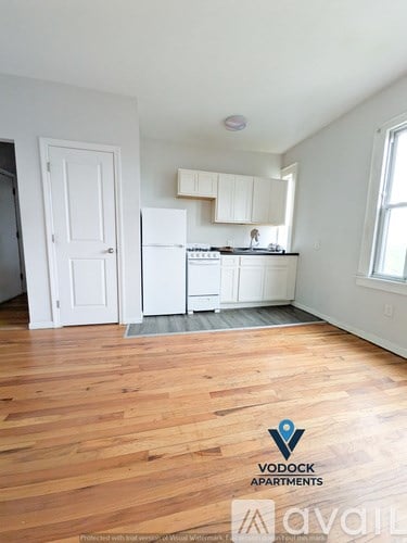 A kitchen with wooden floors and white appliances.