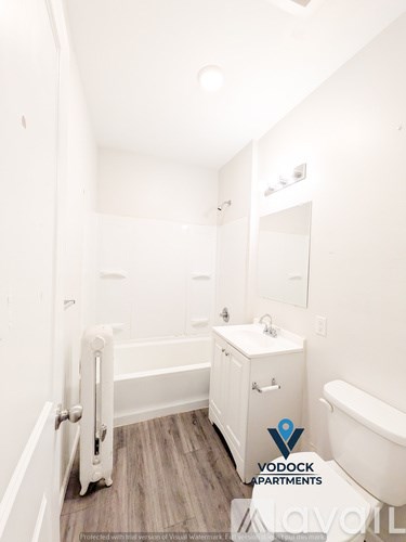 A white bathroom with a Vodock Apartments logo.