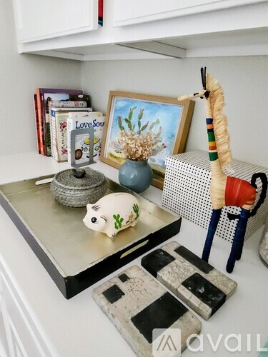 A kitchen counter with a piggy bank, a vase, and a picture frame.