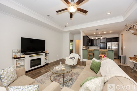 A living room with a white couch and a flat screen TV.