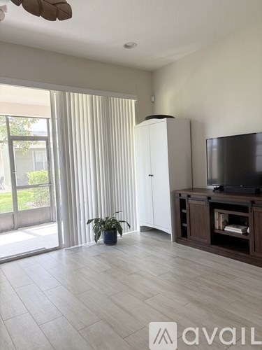 A living room with a television and a plant.