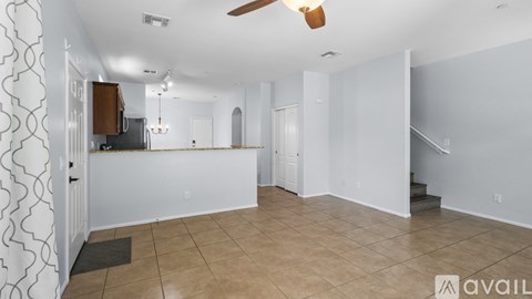 A spacious living room with a television and a fan on the ceiling.