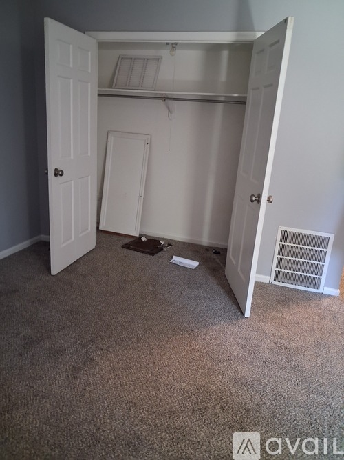 A room with a carpeted floor and a white door.