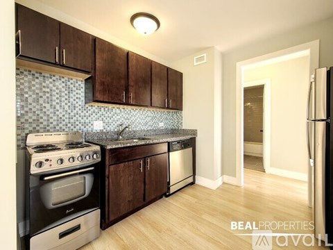 A kitchen with wooden cabinets and a black stove top oven.