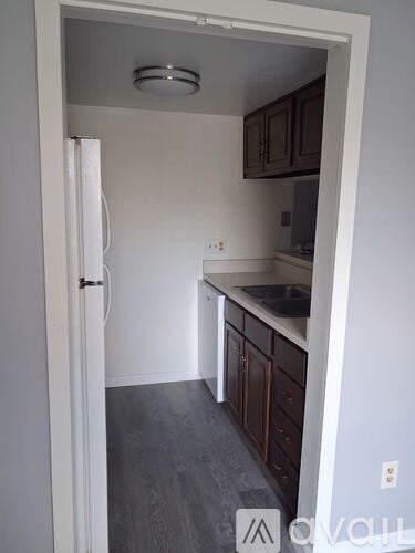 A kitchen with a white door and brown cabinets.