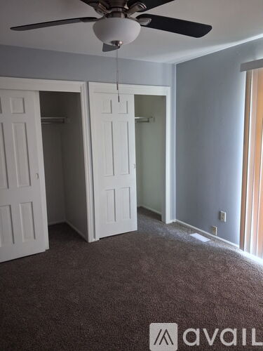 A room with a ceiling fan and two white doors.