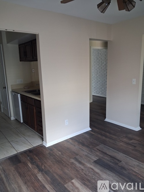 A room with wooden flooring and a ceiling fan.