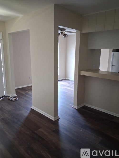 A room with a ceiling fan and wooden flooring.