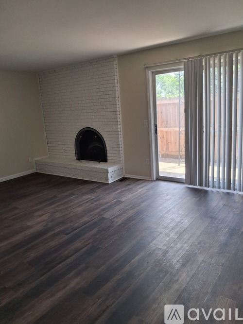A room with a fireplace and wooden floors.