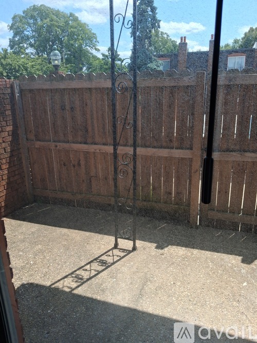 A backyard with a wooden fence and a metal gate.