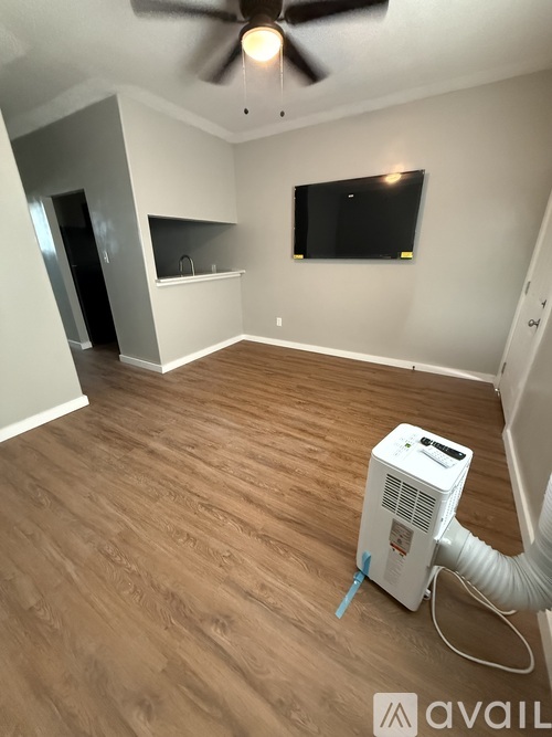 A room with a wood floor and a ceiling fan.