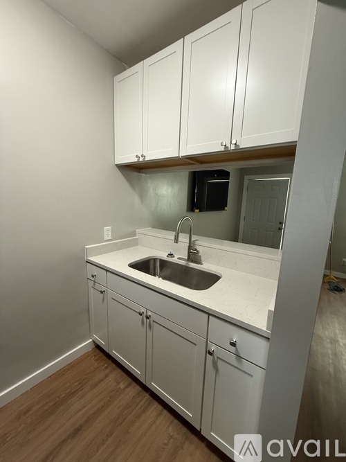 A kitchen with white cabinets and a sink.