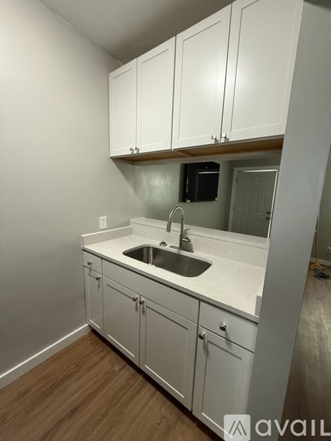 A kitchen with white cabinets and a sink.