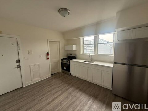 A kitchen with a stainless steel refrigerator, sink, and cabinets.