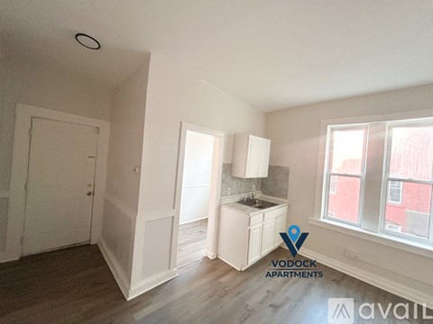 A Vodock Apartments listing shows a small, empty kitchen with white cabinets and a window.