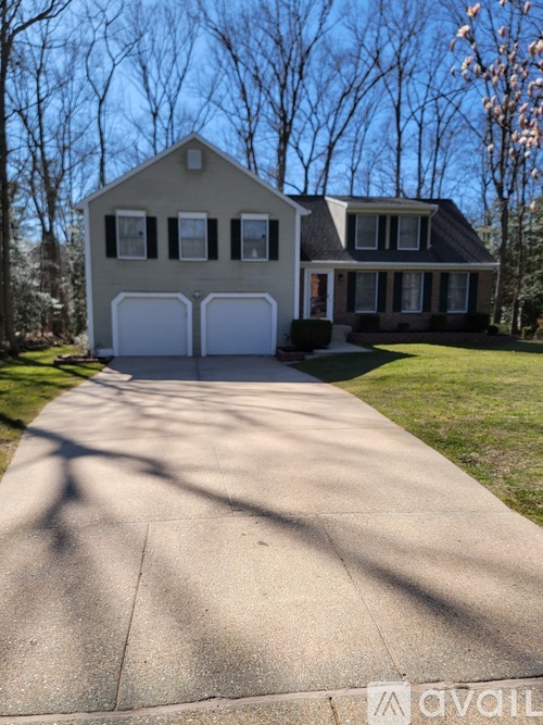 A two-story house with a driveway in front.