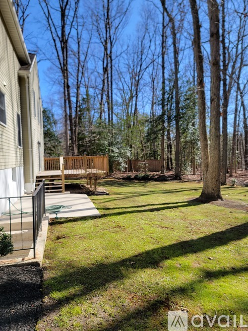 A backyard with a deck and a fence.