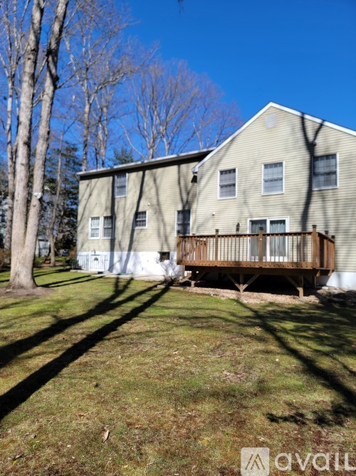 A two-story house with a deck in the backyard.