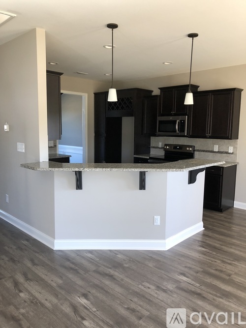 A kitchen with a black refrigerator and a white counter.