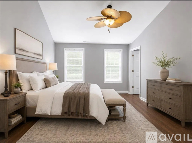 A bedroom with a bed, a dresser, and a ceiling fan.