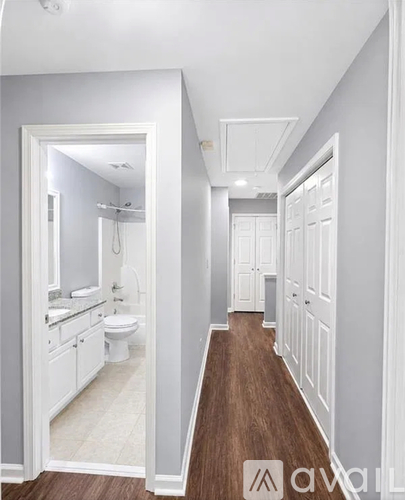 A white bathroom with a toilet, sink, and mirror.