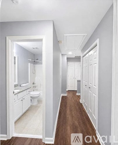 A white bathroom with a toilet, sink, and mirror.