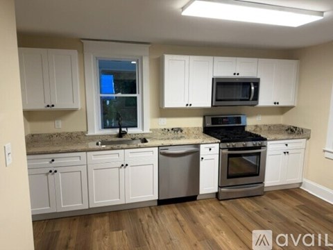 A kitchen with white cabinets and a granite countertop.