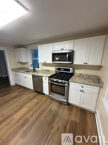 A kitchen with white cabinets and a granite countertop.
