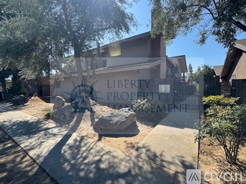 A sign that says "LIBERTY PROPERTY MANAGEMENT" is in front of a building.