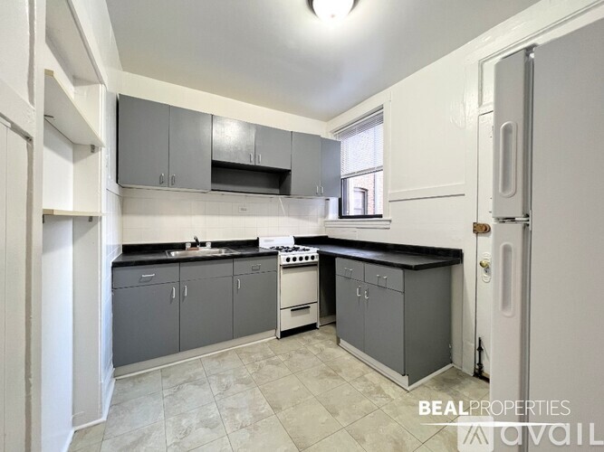 A kitchen with a white door and a white fridge.