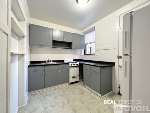 A kitchen with a white door and a white fridge.