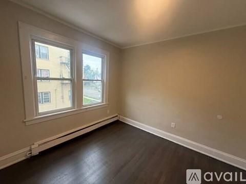 A room with a window and a wooden floor.