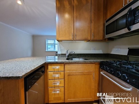 A kitchen with wooden cabinets and a granite countertop.