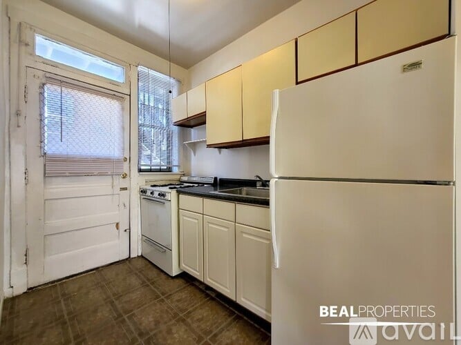 A kitchen with white appliances and brown cabinets.