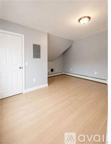 A room with wooden flooring and white walls.