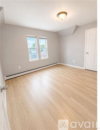 A room with wooden flooring and a window.