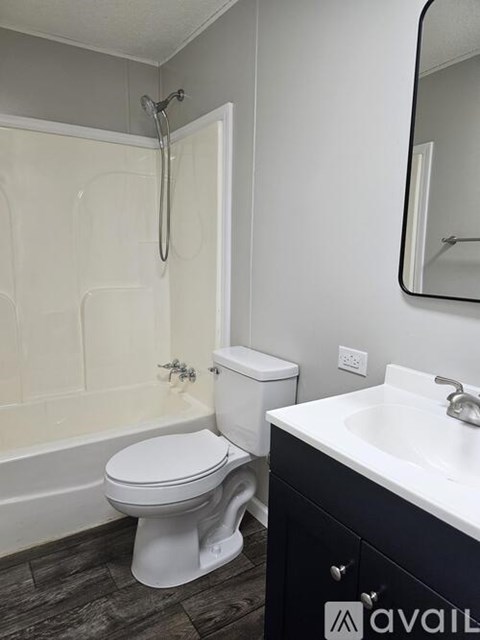 A white toilet sits next to a bathtub in a bathroom.
