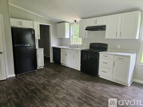 A kitchen with black appliances and white cabinets.