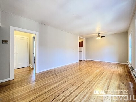 A room with wooden flooring and a ceiling fan.
