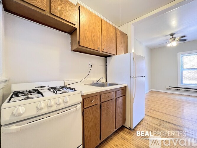 A kitchen with a white stove and wooden cabinets.