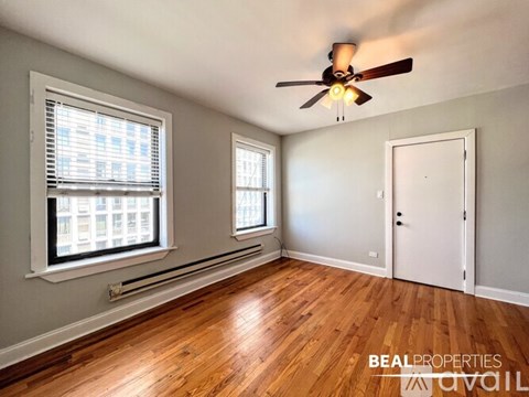 A room with a ceiling fan and two windows.
