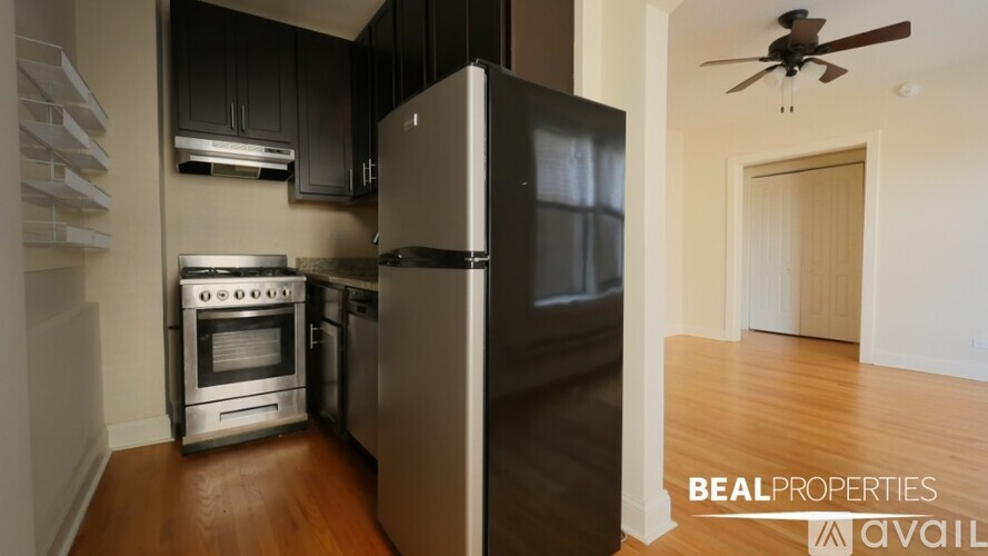 A kitchen with a refrigerator, oven, and stove.