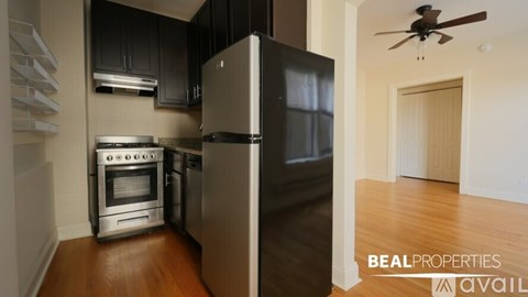 A kitchen with a refrigerator, oven, and stove.