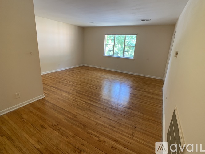 A room with wooden flooring and a window.
