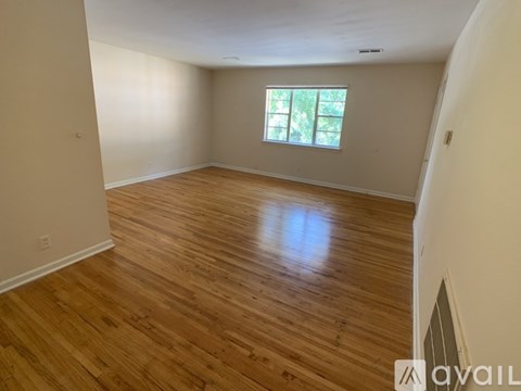 A room with wooden flooring and a window.