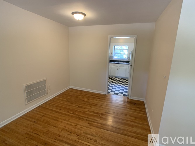 A room with wooden flooring and a window with blinds.