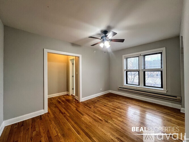 A room with a ceiling fan and wooden flooring.