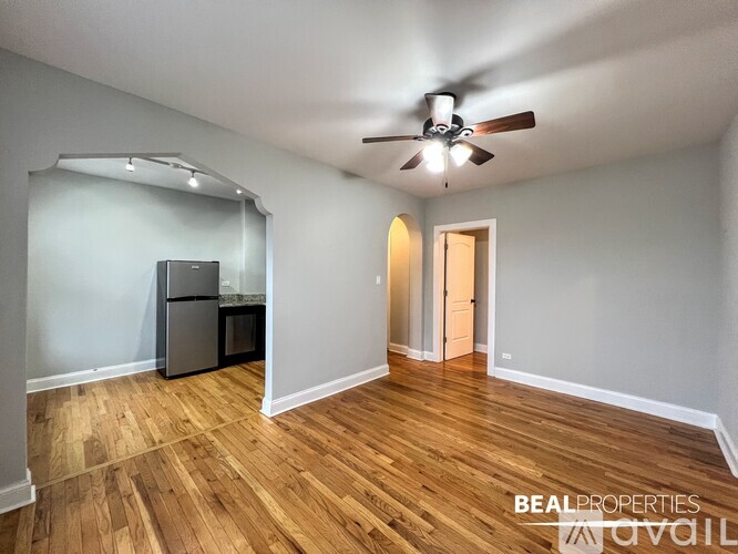 A room with a ceiling fan and wooden flooring.
