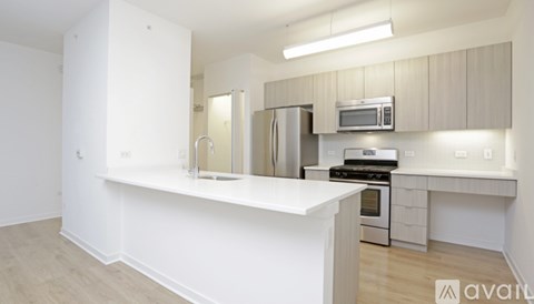 A kitchen with white countertops and stainless steel appliances.