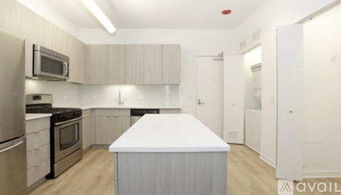 A kitchen with a white island in the middle.